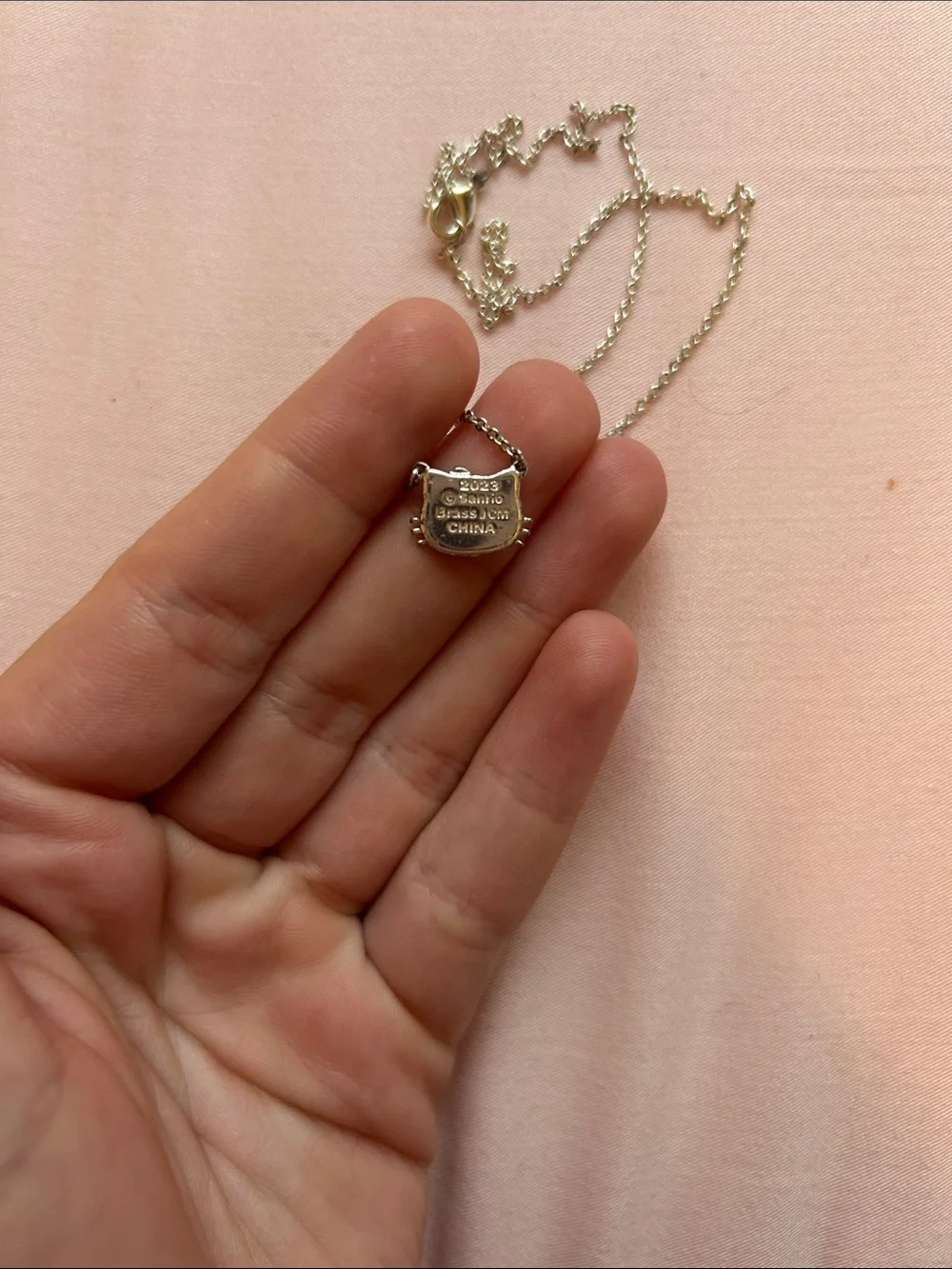 Hello Kitty Silver Necklace with White Enamel Face and Gold Flower Accent